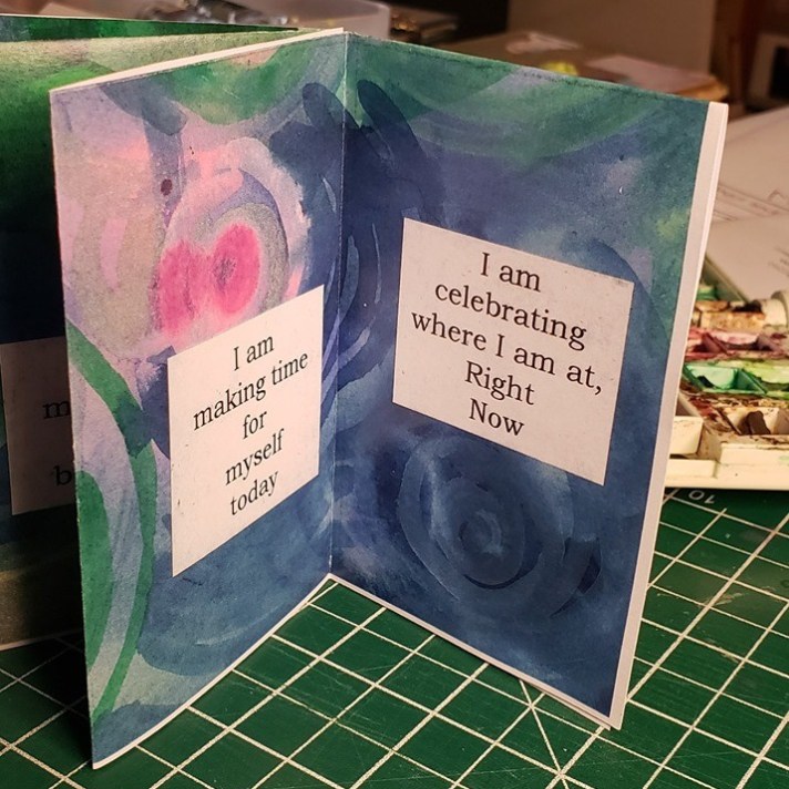 Image from self-care mini-zine by Kelly Wolf, Open Heart Arts. Text of page reads: "I am celebrating where I am Right Now."
